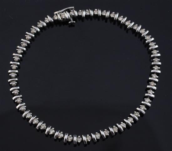 A 9ct white gold and diamond line bracelet, 8in.